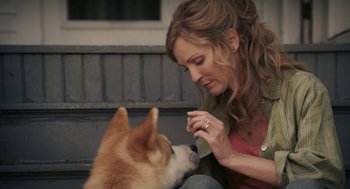 Movie still from “Hachi: A Dog's Tale” (2009), directed by Lasse Hallström – A woman sitting next to a brown and white dog; Close Up shot, Over the shoulder angle