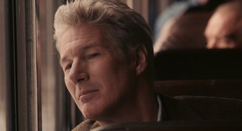 Movie still from “Hachi: A Dog's Tale” (2009), directed by Lasse Hallström – A person sitting in a chair; Close Up shot, Over the shoulder angle
