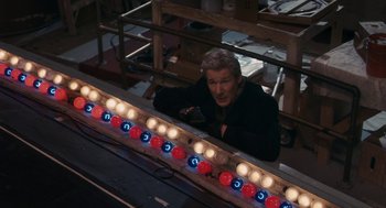 Movie still from “Hachi: A Dog's Tale” (2009), directed by Lasse Hallström – A man sitting in front of a row of lights; Wide shot, High angle