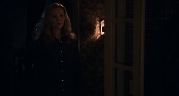 Movie still from “Hachi: A Dog's Tale” (2009), directed by Lasse Hallström – A woman standing in front of a door in a dark room; Medium shot, Over the shoulder angle