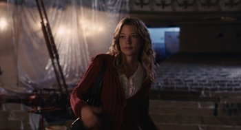 Movie still from “Hachi: A Dog's Tale” (2009), directed by Lasse Hallström – A beautiful young woman holding a purse while standing in a room; Medium shot, Over the shoulder angle
