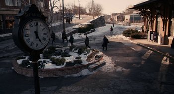 Movie still from “Hachi: A Dog's Tale” (2009), directed by Lasse Hallström – A group of people walking down a street next to a clock; Extreme Wide shot, High angle