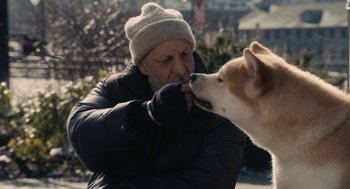 Movie still from “Hachi: A Dog's Tale” (2009), directed by Lasse Hallström – A man and a dog are playing with each other outside; Close Up shot, Over the shoulder angle