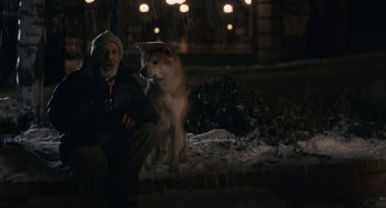 Movie still from “Hachi: A Dog's Tale” (2009), directed by Lasse Hallström – An old man sitting next to a dog in the snow at night; Wide shot, Over the shoulder angle