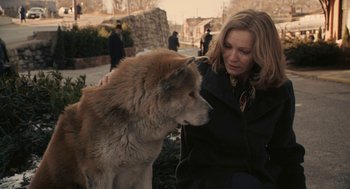 Movie still from “Hachi: A Dog's Tale” (2009), directed by Lasse Hallström – A woman sitting next to a brown and white dog; Medium shot, High angle