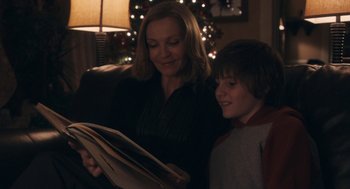 Movie still from “Hachi: A Dog's Tale” (2009), directed by Lasse Hallström – A woman and a boy looking at a book; Medium shot, Over the shoulder angle