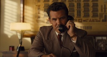 Movie still from “Hail, Caesar!” (2016), directed by Ethan Coen – A man talking on a phone while wearing a suit; Medium shot, Low angle