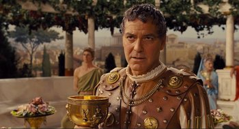 Movie still from “Hail, Caesar!” (2016), directed by Ethan Coen – A man dressed as a roman soldier holding a gold cup; Close Up shot, Over the shoulder angle