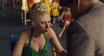 Movie still from “Hail, Caesar!” (2016), directed by Ethan Coen – A woman in a green dress sitting next to a man; Close Up shot, Over the shoulder angle