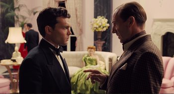 Movie still from “Hail, Caesar!” (2016), directed by Ethan Coen – Two men in suits talking to each other in a living room; Medium shot, Over the shoulder angle