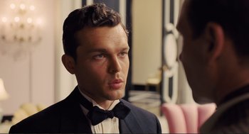 Movie still from “Hail, Caesar!” (2016), directed by Ethan Coen – A man wearing a suit and bow tie; Close Up shot, Over the shoulder angle
