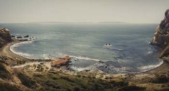 Movie still from “Hail, Caesar!” (2016), directed by Ethan Coen – An aerial view of a body of water with a house in the background; Extreme Wide shot, High angle