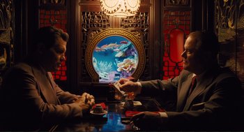 Movie still from “Hail, Caesar!” (2016), directed by Ethan Coen – Two men sitting at a table in front of an aquarium; Medium shot, Over the shoulder angle