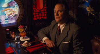 Movie still from “Hail, Caesar!” (2016), directed by Ethan Coen – A man sitting at a table in front of a window; Medium shot, Low angle