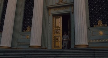 Movie still from “Hail, Caesar!” (2016), directed by Ethan Coen – A man standing in front of an entrance to a building; Extreme Wide shot, Low angle