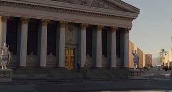 Movie still from “Hail, Caesar!” (2016), directed by Ethan Coen – Two people walking up the steps of a large building; Extreme Wide shot, Low angle