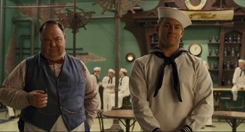 Movie still from “Hail, Caesar!” (2016), directed by Ethan Coen – Two men dressed in sailor's outfits standing next to each other; Medium shot, Over the shoulder angle
