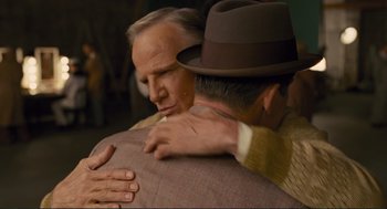 Movie still from “Hail, Caesar!” (2016), directed by Ethan Coen – A man in a hat hugging another man in a suit; Medium shot, Over the shoulder angle