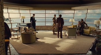 Movie still from “Hail, Caesar!” (2016), directed by Ethan Coen – A group of people standing in front of a large window; Extreme Wide shot, Low angle