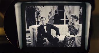 Movie still from “Hail, Caesar!” (2016), directed by Ethan Coen – A man sitting on a couch in front of two women; Medium shot, Low angle