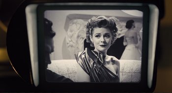 Movie still from “Hail, Caesar!” (2016), directed by Ethan Coen – An old photo of a woman sitting on a couch; Close Up shot, Over the shoulder angle
