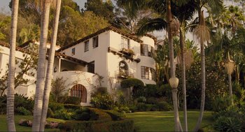 Movie still from “Hail, Caesar!” (2016), directed by Ethan Coen – A large white building with a palm tree in front of it; Extreme Wide shot, High angle