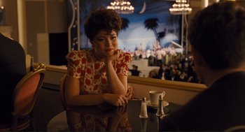 Movie still from “Hail, Caesar!” (2016), directed by Ethan Coen – A woman sitting at a table in front of a crowd; Medium shot, Over the shoulder angle