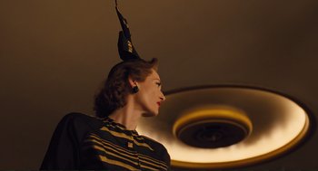 Movie still from “Hail, Caesar!” (2016), directed by Ethan Coen – A woman wearing a black and yellow dress and a black hat; Medium shot, Low angle