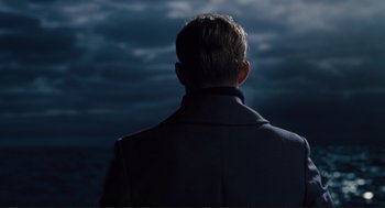Movie still from “Hail, Caesar!” (2016), directed by Ethan Coen – A man standing in front of a cloudy sky; Medium shot, Low angle