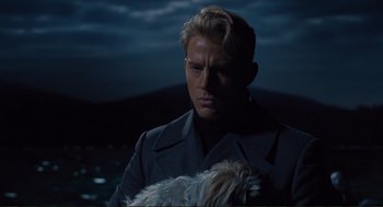 Movie still from “Hail, Caesar!” (2016), directed by Ethan Coen – A man holding a white dog in his arms; Close Up shot, Over the shoulder angle