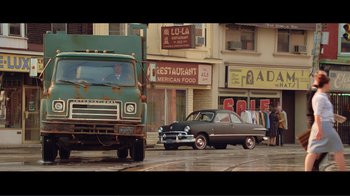 Movie still from “Hairspray” (2007), directed by Adam Shankman – An old car parked on the side of the street; Wide shot, High angle