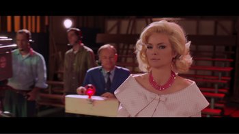 Movie still from “Hairspray” (2007), directed by Adam Shankman – A woman in a white and pink dress and a man in a suit; Medium shot, Low angle