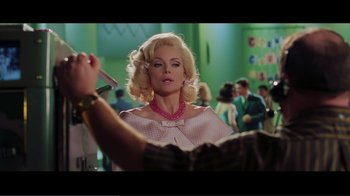 Movie still from “Hairspray” (2007), directed by Adam Shankman – A woman with blonde hair and a pink necklace; Medium shot, Over the shoulder angle