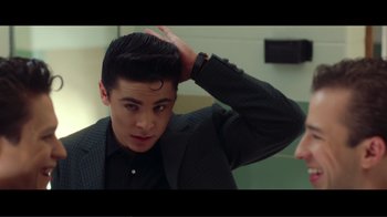 Movie still from “Hairspray” (2007), directed by Adam Shankman – A man with a black jacket and a black shirt is combing his hair in front of a mirror; Close Up shot, Over the shoulder angle