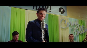 Movie still from “Hairspray” (2007), directed by Adam Shankman – A young man standing in front of a microphone in a room; Medium shot, Low angle