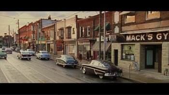Movie still from “Hairspray” (2007), directed by Adam Shankman – An old car is driving down the street; Extreme Wide shot, High angle