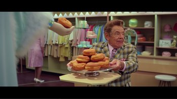 Movie still from “Hairspray” (2007), directed by Adam Shankman – An older man in a suit is holding a plate of donuts; Medium shot, Over the shoulder angle