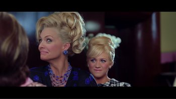 Movie still from “Hairspray” (2007), directed by Adam Shankman – Two women with very long blonde hair and blue jewelry; Medium shot, Over the shoulder angle