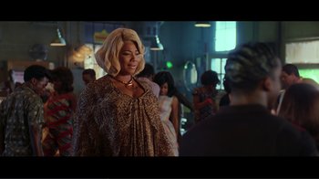 Movie still from “Hairspray” (2007), directed by Adam Shankman – A woman with blonde hair is standing next to a crowd; Medium shot, Over the shoulder angle