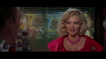 Movie still from “Hairspray” (2007), directed by Adam Shankman – A woman with blonde hair wearing a pink dress and a pink necklace; Close Up shot, Over the shoulder angle