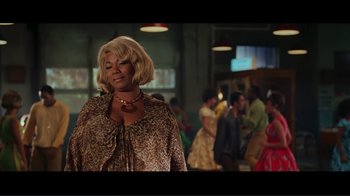 Movie still from “Hairspray” (2007), directed by Adam Shankman – A woman with blonde hair standing in front of a group of people; Medium shot, Low angle