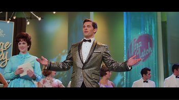 Movie still from “Hairspray” (2007), directed by Adam Shankman – A man wearing a suit and a bow tie in front of a group of people; Medium shot, Low angle