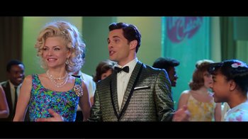 Movie still from “Hairspray” (2007), directed by Adam Shankman – A man wearing a suit and bow tie in front of a crowd; Medium shot, Over the shoulder angle