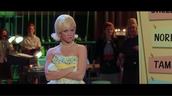 Movie still from “Hairspray” (2007), directed by Adam Shankman – A woman in a yellow dress with her arms crossed; Medium shot, Low angle