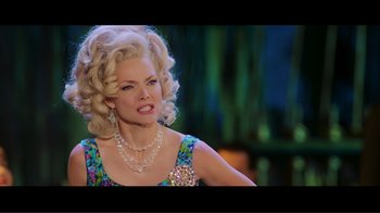 Movie still from “Hairspray” (2007), directed by Adam Shankman – A woman with blonde curly hair wearing a necklace; Medium shot, Low angle