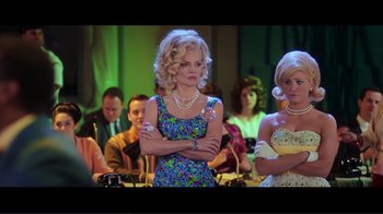 Movie still from “Hairspray” (2007), directed by Adam Shankman – A woman standing in front of a group of people; Medium shot, Over the shoulder angle