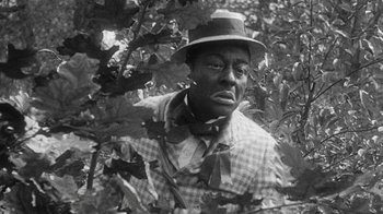 An old black and white photo of a man wearing a hat