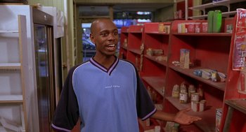 Movie still from “Half Baked” (1998), directed by Tamra Davis – A man standing in front of shelves in a store; Medium shot, Low angle
