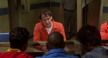 Movie still from “Half Baked” (1998), directed by Tamra Davis – A man in an orange jacket looking in the mirror; Medium shot, Over the shoulder angle