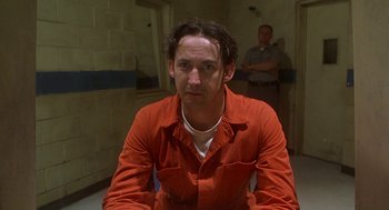 Movie still from “Half Baked” (1998), directed by Tamra Davis – A man in an orange prison uniform sitting in a cell; Close Up shot, Low angle